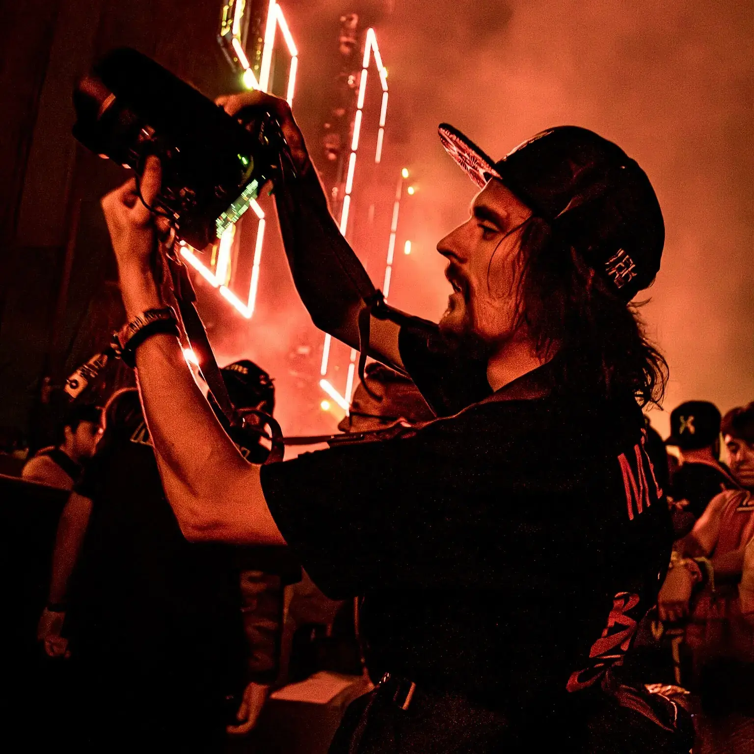 Brady Colee photographing a live performance under orange stage lights