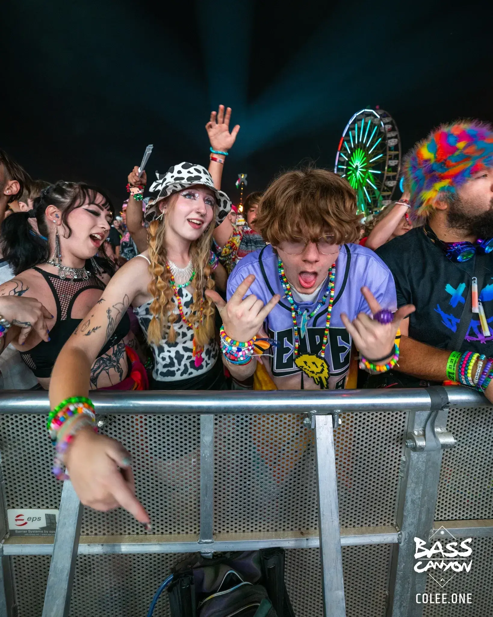 Fans in patterned clothing reacting at the metal front barrier at night, Bass Canyon 2023 at The Gorge Amphitheatre, George, Washington