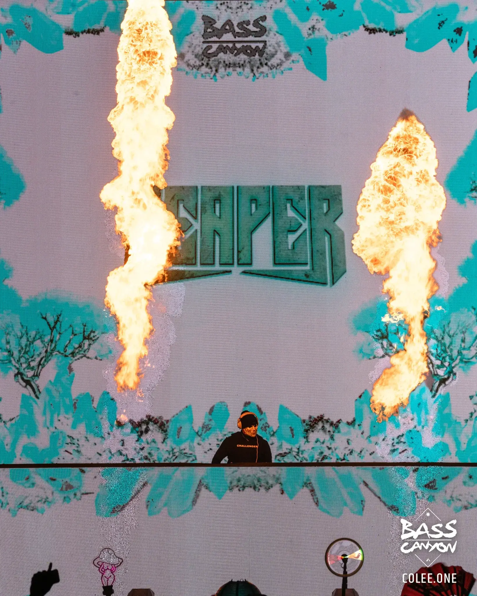 Close stage view of a performer beneath two flame columns and pale blue graphics, Bass Canyon 2023 at The Gorge Amphitheatre, George, Washington